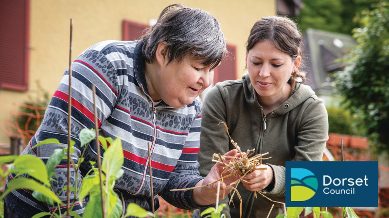A young woman helping an older woman with gardening