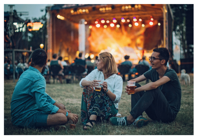 three people sat in front of outdoor stage