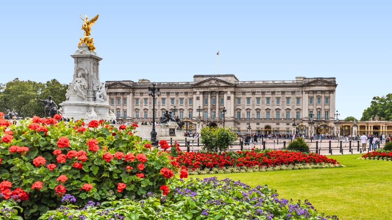 Buckingham Palace and Victoria Monument with gardens of The Mall in the foreground
