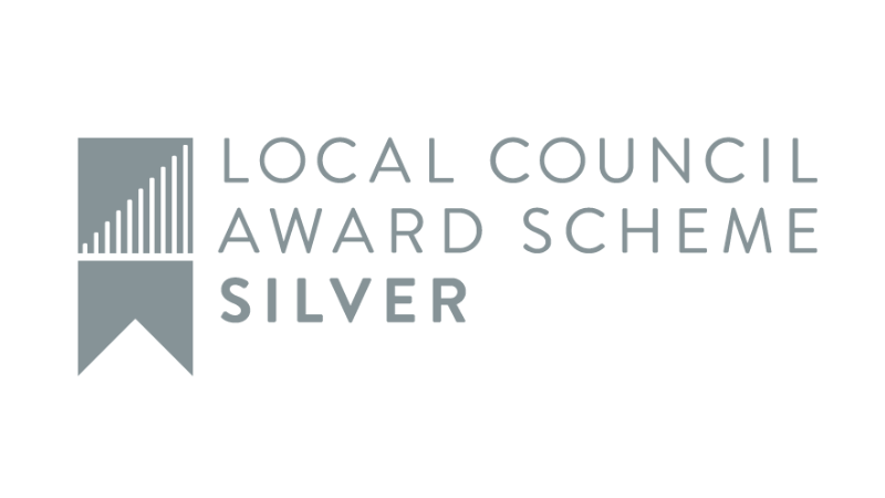 Dark blue background with metallic silver stars scattered across bottom and right side. Logo for Local Council Award Scheme Silver in top left