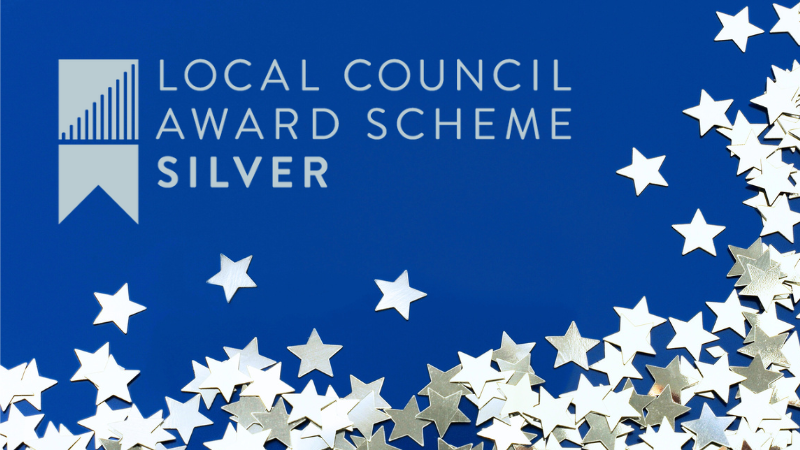 Blue background with silver stars scattered around bottom and right edge. Local Council Award Scheme Silver logo ranged to left